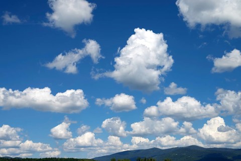 Blue sky with many white clouds over a mountain landscape, Bavarian Forest above Deggendorf,