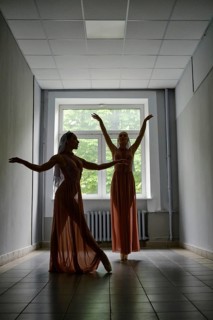 Silhouette of two female dancers rehearsing choreography in the hallway of theatre