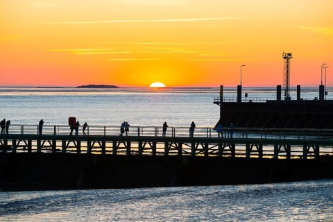Silhouettes of several people on the pier free canal, jetty, couples and individuals watching the