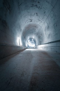 A long tunnel with cold concrete walls and a straight structure that looks industrial and sterile,