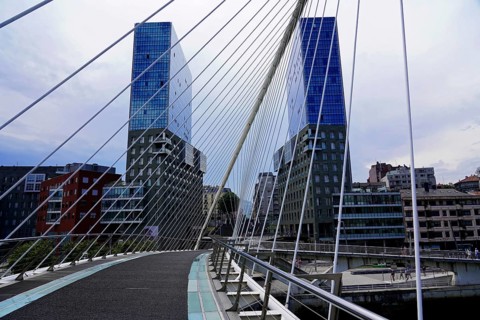 Pedestrian bridge Zubizuri, White Bridge, Bilbao, Pedestrian bridge with modern skyscrapers in the