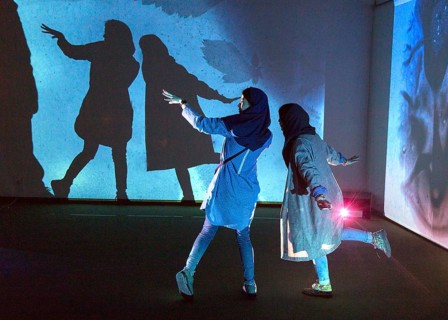 Two woman look at an exhibition by the German artist Otto Piene in Tehran on 6 April 2015 and make