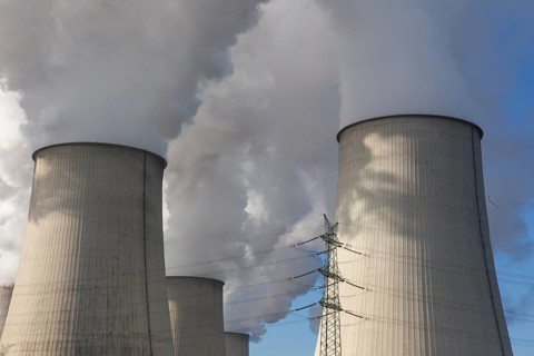 Steam rises from the cooling towers of the Vattenfall power plant in Jaenschwalde, power lines and