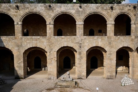 Medieval fortress with symmetrical arcades and lion statue in the courtyard, outdoor area,