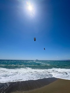 Kitesurfer Kitesurfer takes off in strong wind and waves rough sea moving sea flies with inflated
