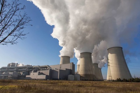 Steam rises from the cooling towers of the Vattenfall power plant in Jaenschwalde, power lines and