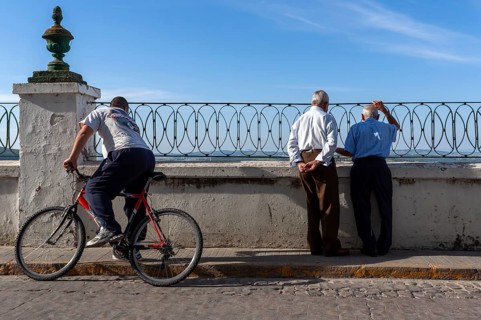 Senior citizen looking over a parapet on the street, Vejer, Andalusia, Spain, Europe