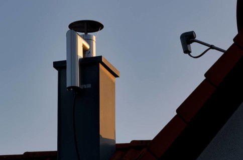 Retrofitted chimney on roof, with dust separator, electrostatic filtering of soot particles from