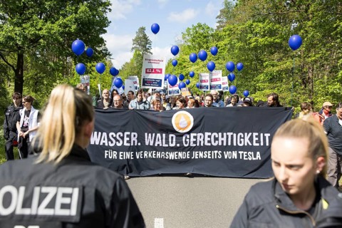 Participants with banner Water. Forest. Justice. For a traffic turnaround beyond Tesla and balloons