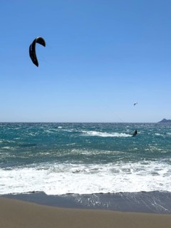 Kitesurfer kite surfer surfing in strong wind and waves rough sea choppy sea with inflated sail,