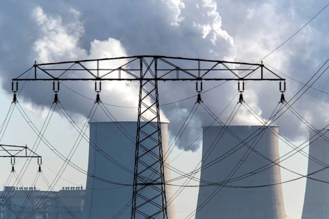 Steam rises from the cooling towers of the Vattenfall power plant in Jaenschwalde, power lines and