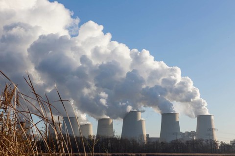 Steam rises from the cooling towers of the Vattenfall power plant in Jaenschwalde, power lines and