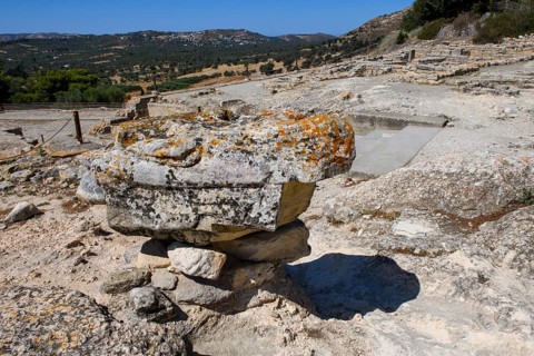Stone fragment column fragment remains of palace on hill of Phaistos excavation site of Minoan