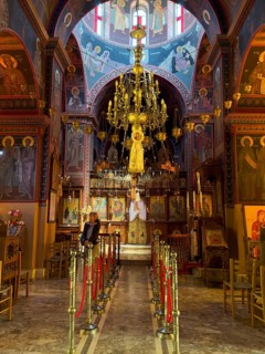 Tourist visiting sanctuary interior of orthodox church with in background chandelier chandelier