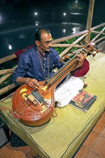 Indian man playing the long-necked lute or Sarasvati vina, Thekkady, Kerala, India, Asia