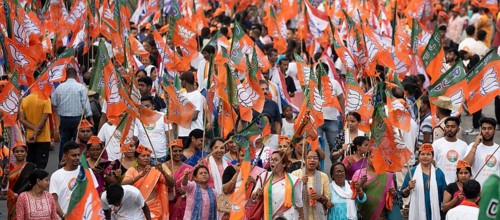 Bharatiya Janata Party (BJP) supporters holding BJP flags arrives to to see a roadshow of Union