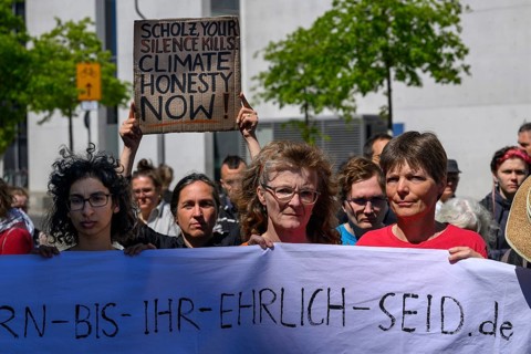 Activists at a silent protest in support of hunger until you are honest . The poster behind her