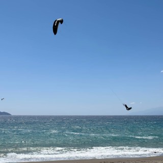 Kitesurfer Kitesurfer takes off in strong wind and waves rough sea moving sea flies with inflated