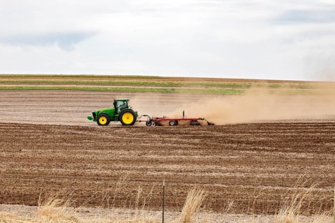 Schaller, Iowa, A cloud of dust blows behind the tractor as a farmer plows his field on a windy day