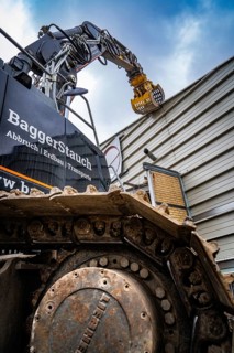 Close-up of an excavator with a steel chain demolishing a building, demolition, Saarbruecken,