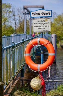 Lifebuoy with sign Abuse will be punished and information board Blaue Brueck in Friedrichstadt,