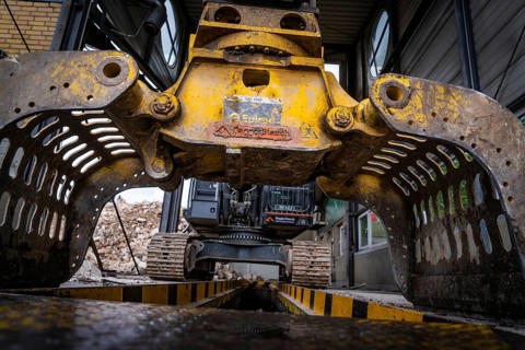 Close-up of an excavator with grab arm carrying out demolition work in a building, demolition,