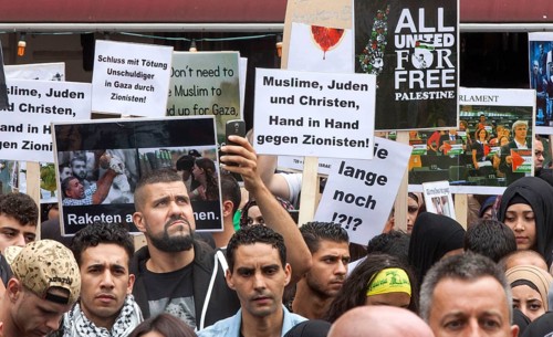 Muslims, Jews and Christians, hand in hand against Zionists, can be read on a poster during the Al