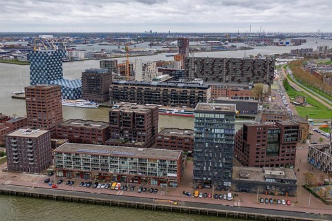 Modern residential complexes and buildings line the riverbank, shaping the urban architecture under