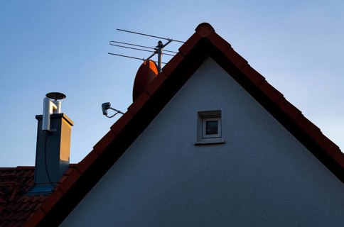 Retrofitted chimney on roof, with dust separator, electrostatic filtering of soot particles from