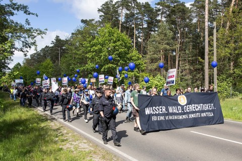 Participants with banner Water. Forest. Justice. For a traffic turnaround beyond Tesla and balloons