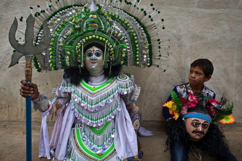 Purulia Chhau dancer playing the role of the hindu god Shiva, the son of the dancer is watching his