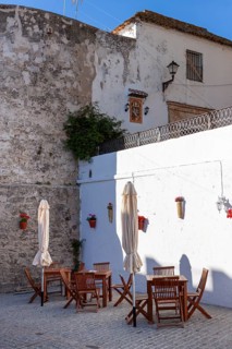 Tables and chairs of a small cafe in the white town of Vejer in the mountains, Andalusia, Spain,
