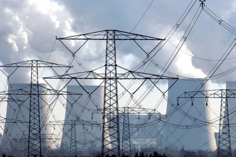 Steam rises from the cooling towers of the Vattenfall power plant in Jaenschwalde, power lines and