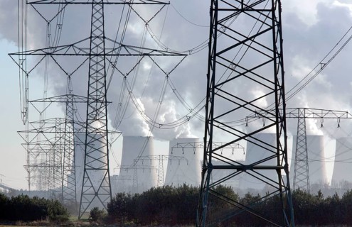 Steam rises from the cooling towers of the Vattenfall power plant in Jaenschwalde, power lines and