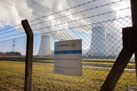 Steam rises from the cooling towers of the Vattenfall power plant in Jaenschwalde, power lines and