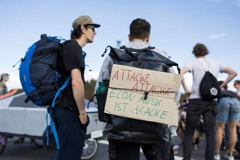 Participants with cardboard sign Attack, attack, Elon Musk is poop at the demonstration Water.