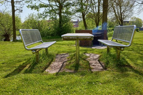 Public barbecue area with brick-built, smoking barbecue and stainless steel tables and benches in