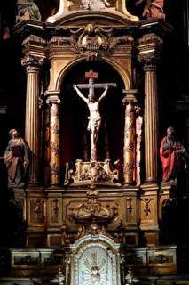 Iglesia San Nicolas de Bari, A baroque altar with a crucifix and figures of saints, richly
