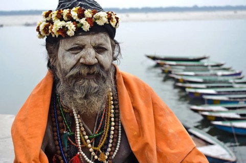 Portrait of a hindu ascetic, sadhu belonging to the naga order, Ganges river in the background,