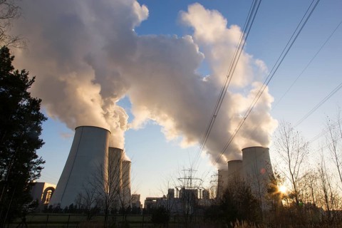 Steam rises from the cooling towers of the Vattenfall power plant in Jaenschwalde, power lines and