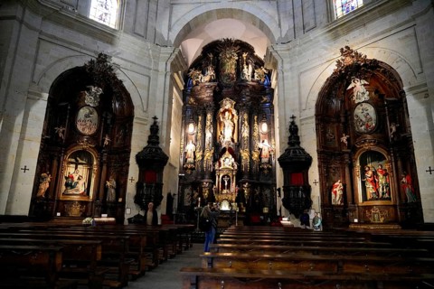 Iglesia San Nicolas de Bari, altar in a baroque church with people sitting in the pews, ornate
