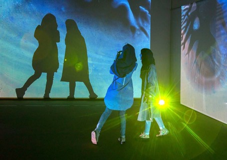 Two woman look at an exhibition by the German artist Otto Piene in Tehran on 6 April 2015 and make