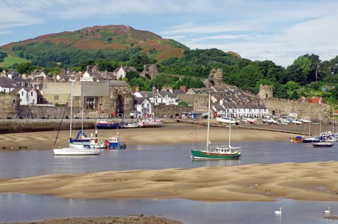 Small harbour at low tide with sailing ships, parts of an old fortification, Conwy, Wales, Great