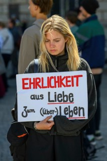 Participant in a silent demonstration for the hunger strikers. Her poster reads Honesty for the