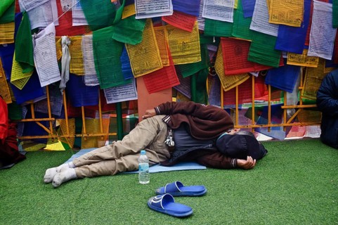 Asian buddhist pilgrim sleeping in the Mahabodhi temple complex, Bodhgaya, Bihar, India. The