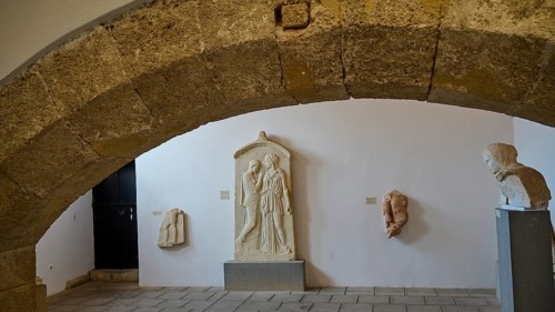 Tomb stele, Krito and Timarista, An exhibition space with ancient stone sculptures and a large