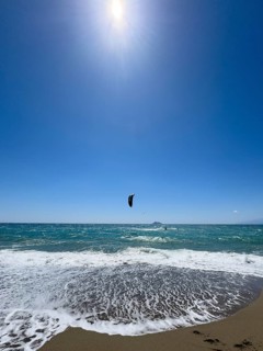 Kitesurfer kite surfer surfing in strong wind and waves rough sea moving sea with inflated sail, in