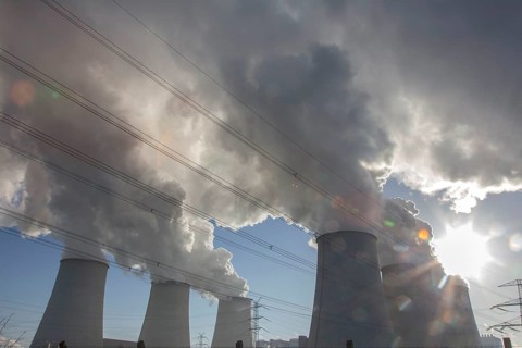 Steam rises from the cooling towers of the Vattenfall power plant in Jaenschwalde, power lines and