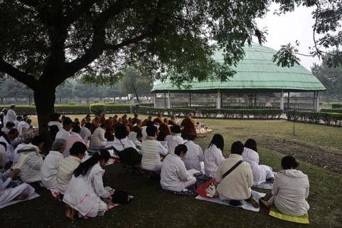 Asian buddhist tourists on pilgrimage, reading scriptures in front of the relic stupa at Vaishali,