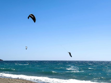 Kitesurfer Kitesurfer takes off in strong wind and waves rough sea moving sea flies with inflated
